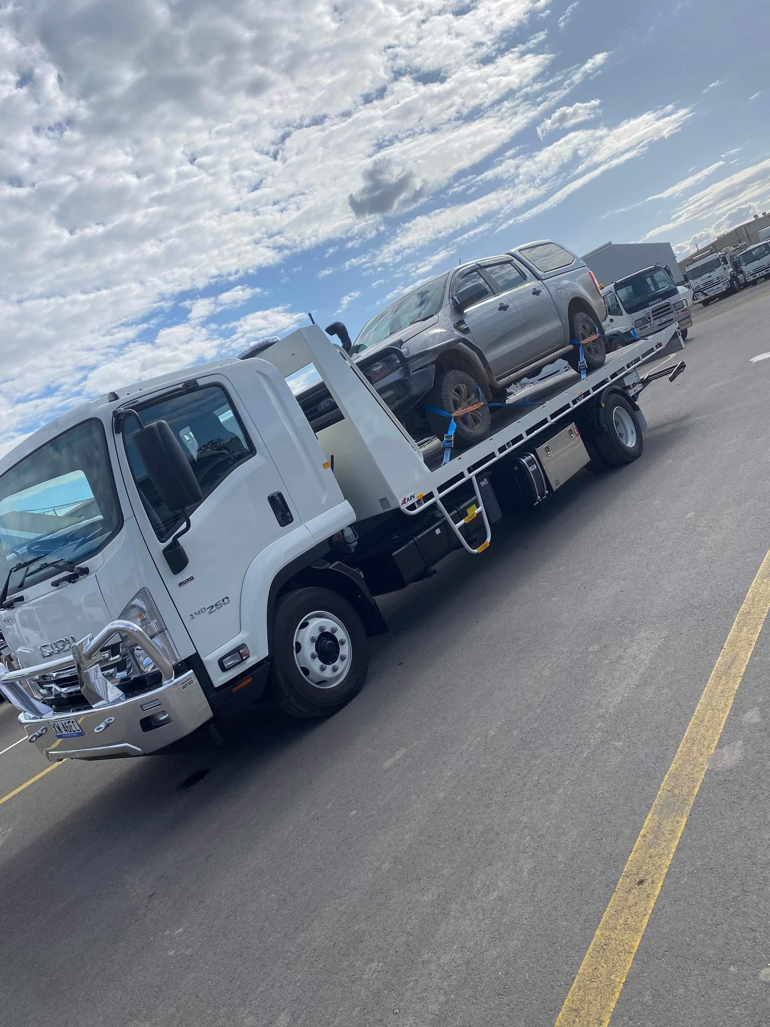 White Clarke's Towing truck loaded with a silver SUV in a truck yard