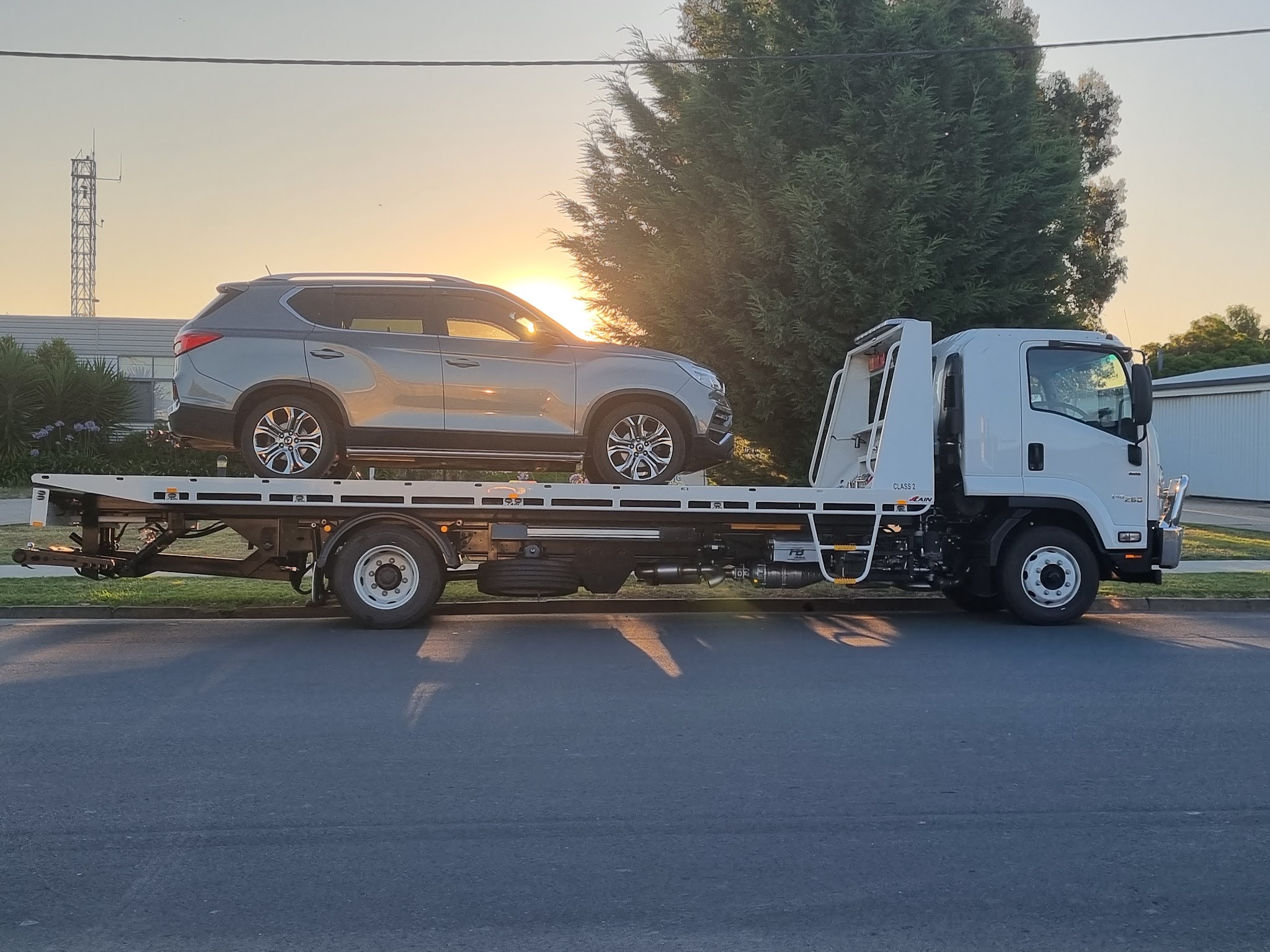 Clarke's Towing flatbed with a silver SUV loaded, parked at sunset in Cobram